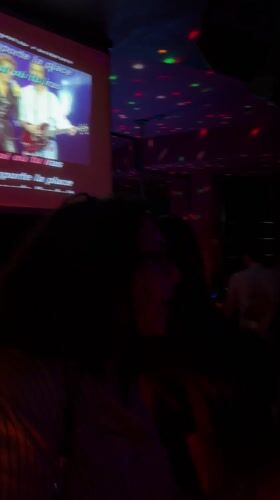 Woman in white tank top spotted at Geneva karaoke bar