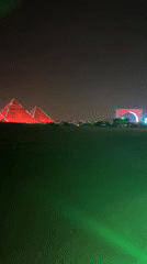 Great Pyramids illuminated red during nighttime event in Giza