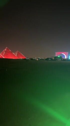Great Pyramids illuminated red during nighttime event in Giza