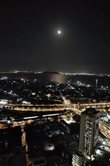 Full moon illuminates Mumbai's nighttime cityscape from elevated views