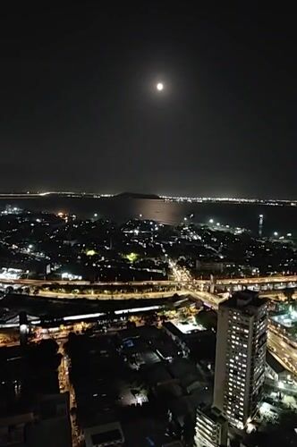 Full moon illuminates Mumbai's nighttime cityscape from elevated views