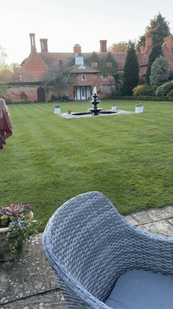 Girl in magenta runs toward fountain on Suffolk estate