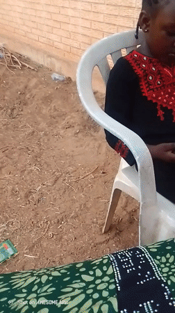 Girl uses tablet, phone while seated outdoors in Nigeria