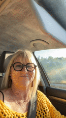 Woman smiles from car passenger seat in Andrézieux-Bouthéon
