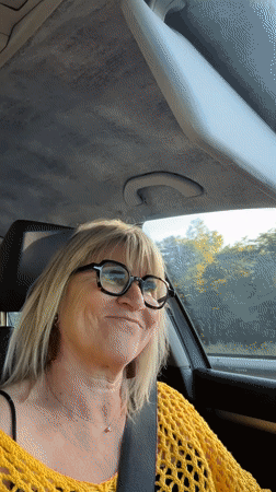 Woman smiles from car passenger seat in Andrézieux-Bouthéon
