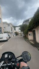 Motorcycle rider navigates residential streets in Budva, Montenegro