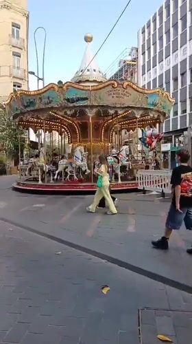 Antique carousel operates in Toulouse square during evening hours