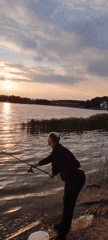 Man enjoys peaceful sunset fishing session at lake