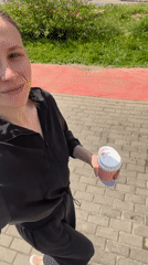Woman enjoys morning coffee walk in Moscow sidewalk