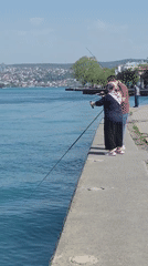Sunny afternoon fishing scene along Bosphorus pier in Sarıyer