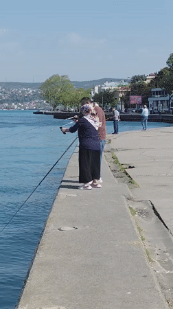 Sunny afternoon fishing scene along Bosphorus pier in Sarıyer