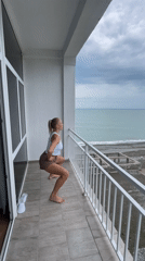Woman conducts morning workout routine on seaside balcony in Abkhazia