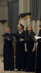 Formal vocal ensemble rehearses in large indoor venue