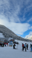 Skiers gather at sunny Bansko resort base area