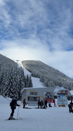 Skiers gather at sunny Bansko resort base area