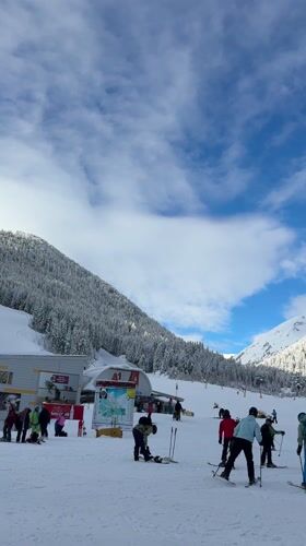 Skiers gather at sunny Bansko resort base area