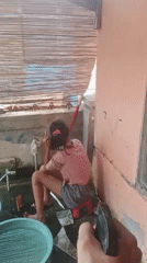 Watering bonsai and plants in a Karawang backyard