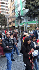 Flag-carrying crowd gathers on La Paz cobblestone streets