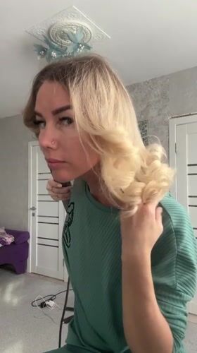 Woman Uses Hair Styling Tool in Abakan Room