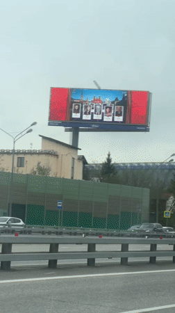 Billboard with five portraits observed from vehicle in Novoivanovskoe