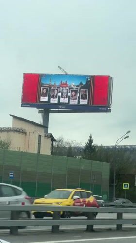 Billboard with five portraits observed from vehicle in Novoivanovskoe