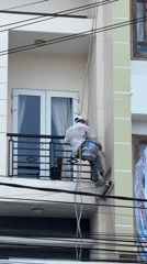 Rope-suspended painter works on multi-story building in Da Lat