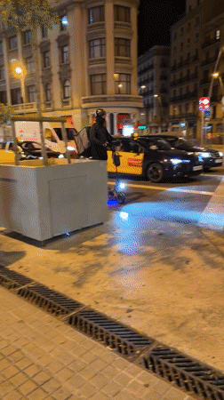 Emergency vehicles with flashing lights patrol Barcelona streets at night