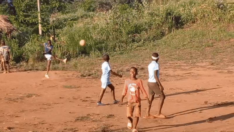 Children play soccer in rural Congolese village field