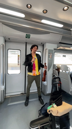 Street musician performs with violin aboard Barcelona train