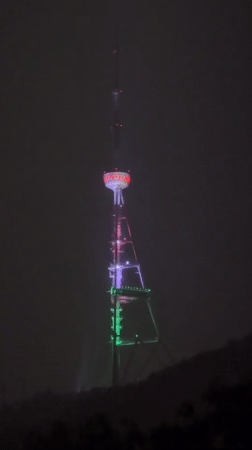 Rainy evening scenes captured around illuminated Tbilisi broadcasting tower