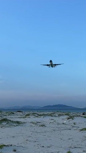 Plane on final approach over Cam Ranh's coastal shoreline