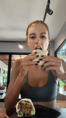 Woman enjoys wrap meal at indoor table in Chalong