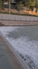 Waterway and park scene along Almaty canal, August 2026