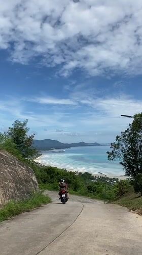 Motorcycle journey documented through coastal Thai village roads and landscapes