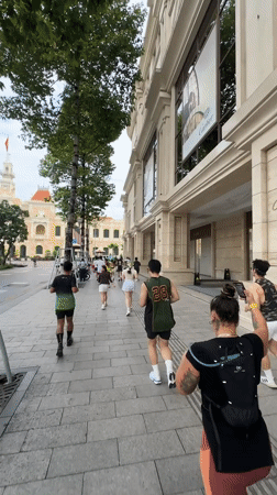 Group runs on urban sidewalk in Thủ Đức, Vietnam
