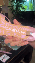 Person displays pink high-heel with written messages in London