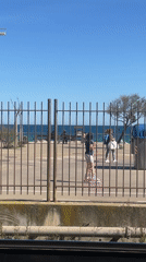Girl roller skates along fence in Badalona, Spain