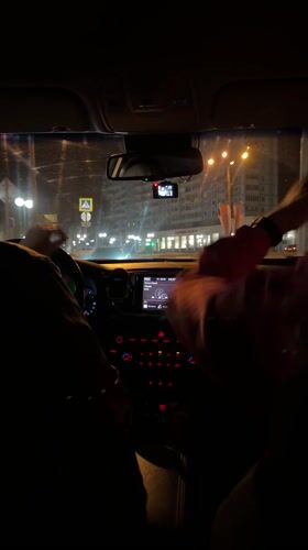 Nighttime car ride captured in Klin, passenger waves