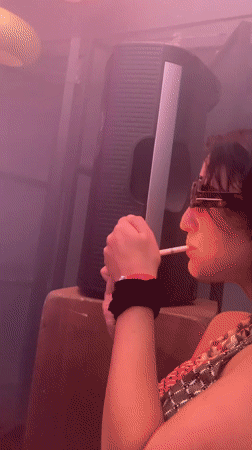 Woman smoking in colorful lit room in Tel Aviv