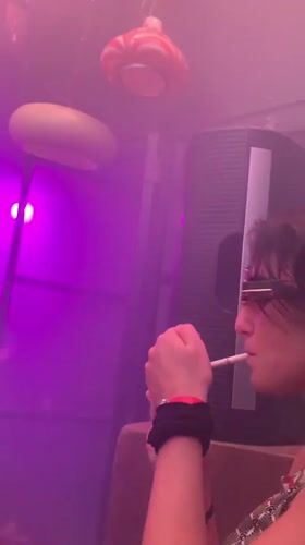 Woman smoking in colorful lit room in Tel Aviv