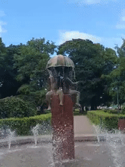 Tallinn park fountain with umbrella sculpture on a clear summer day