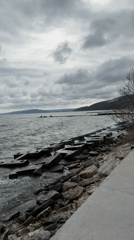 Rough seas crash against Balchik breakwater during cloudy afternoon