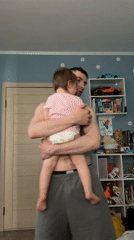 Father holds infant child in Moscow home setting