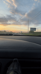 Vehicle travels Russian highway at sunset near Tugurgoy