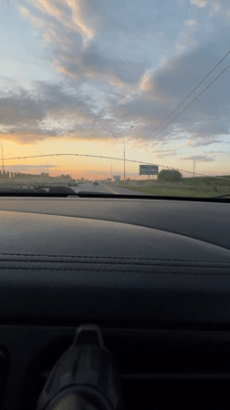 Vehicle travels Russian highway at sunset near Tugurgoy