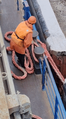 Maritime worker secures boat rope at dock