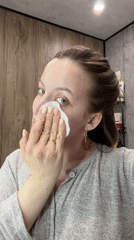Woman performs evening skincare routine in Reshetnikovo bathroom