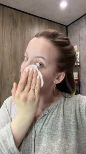 Woman performs evening skincare routine in Reshetnikovo bathroom