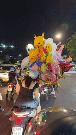 Balloon-laden scooter rolls through Đà Nẵng streets at night