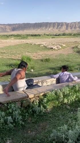 Men play in irrigation canal in rural Pakistan